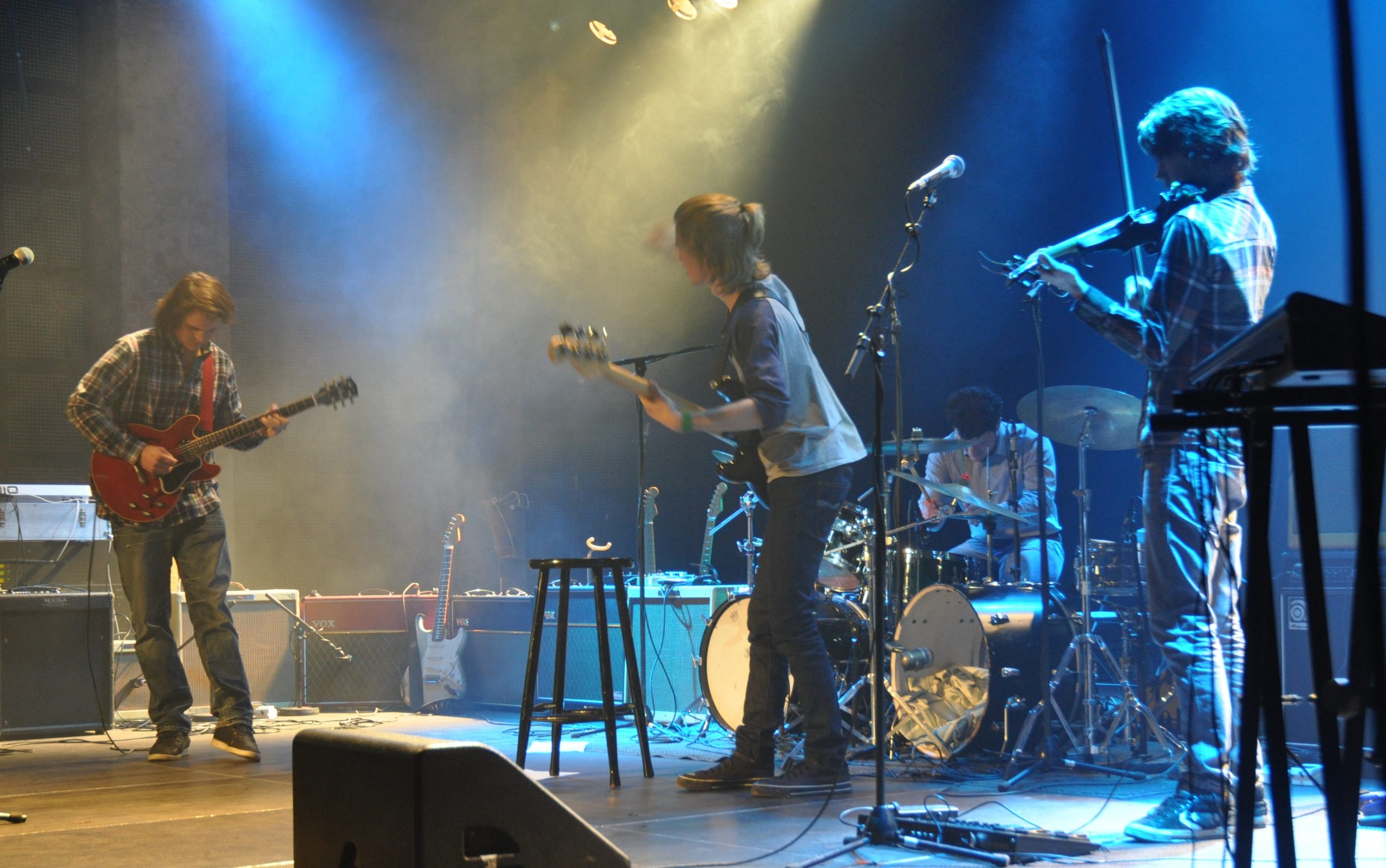 Et band spiller på en scene og ser på hverandre