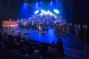 flere forskjellige grupper står på scenen foran publikum under jubileumsshowet
