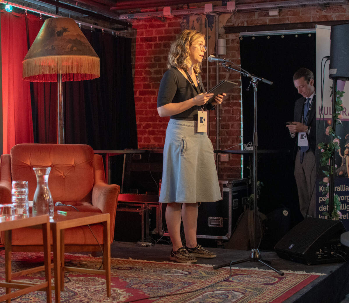 Leder av Kulturrom taler inn i en mikrofon