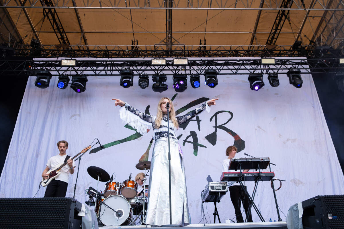 Skaar står på scenen med band bak seg