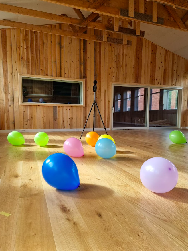 Fargerike ballonger ligger på tregulvet på Børsen